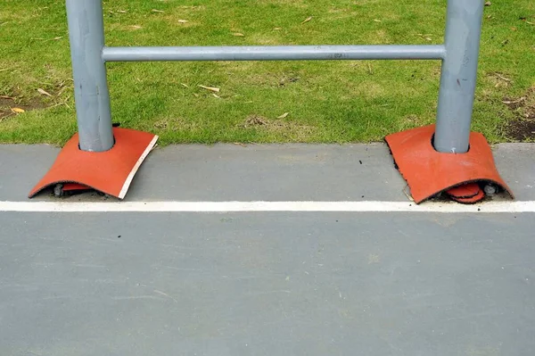 A steel pole of a basketball shooting stand with a red rubber to protect then a player may be .