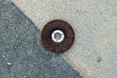 Eski paslı metal bir levhayı kaldırıma yakın tut..