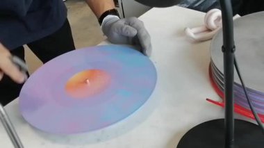 Bir işçi, mühürlendikten sonra gramofon disk kaydının QC 'sini kontrol ediyordu..