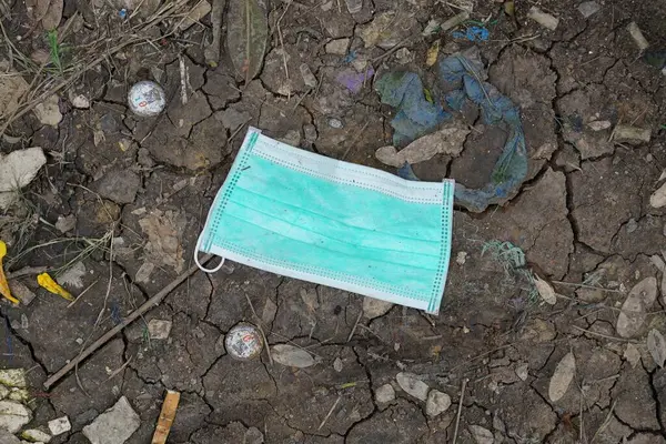 A surgical mask on the ground, pollution of the environment concepts.