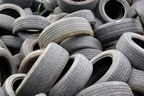 An old car tires stacked in a pile in area a car workshop, disposal recycling concepts.