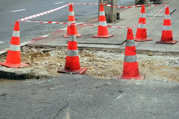 A lot of traffic cones protect beside a street in the constructions site, under construction.