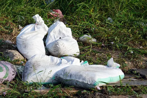 A pile white garbage bags on the ground, environmental pollution concepts.
