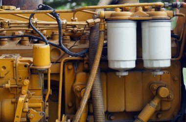 Bir jeneratörün eski sarı renkli motorunun beyaz motor yağ filtre silindirini kapat.