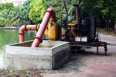 Parktaki göletin yanında büyük bir su pompası motoru..