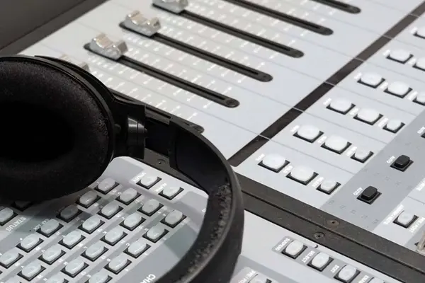 Close-up of headphones on a analog sound mixing console, audio equipment.