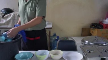 Bir çalışan, dükkanda hazırlanmak için temizlik malzemelerini elle yıkıyordu..