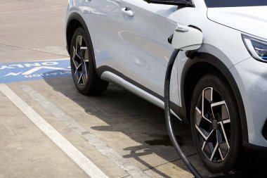 Benzin istasyonundaki otoparkta elektrikli araba şarj istasyonunda bir elektrikli araba şarj oluyordu..