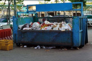 Büyük metal bir çöp tenekesi park yerine konur..