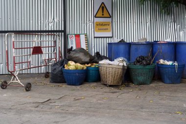 Birçok çöp tenekesi metal duvarların yanına uyarı işaretleri konur..