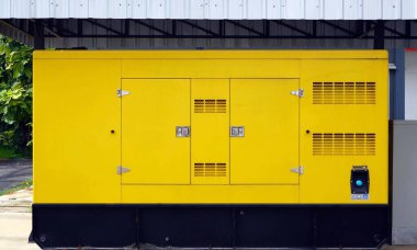 Yerde sarı bir elektrik jeneratörü var..