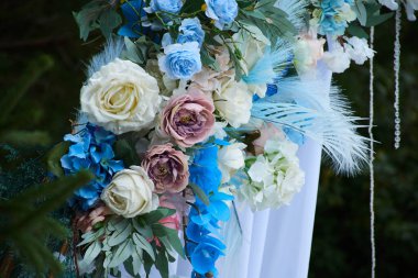 Salon çiçeklerin içinde boğulmuştu: gül ve şakayık çiçekleri, masaların üzerinde okaliptüs olan zarif buketler ve yol boyunca bir yaprak serpintisi, mumların yanıp sönmesiyle aydınlandı..