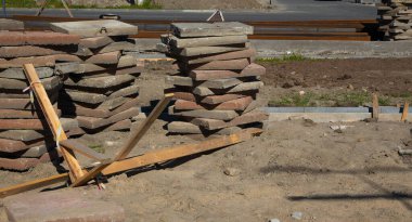 İnşaat alanında ahşap destekli uzun beton levhalar duruyor..