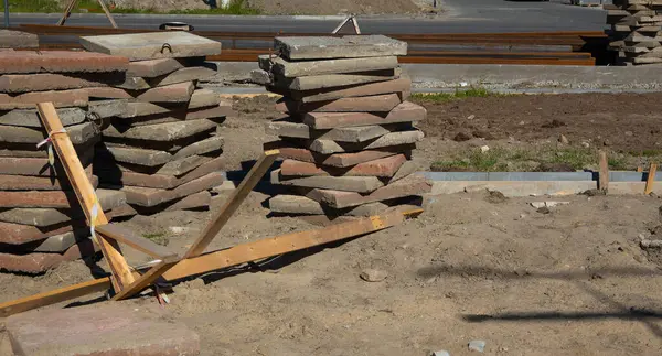 İnşaat alanında ahşap destekli uzun beton levhalar duruyor..