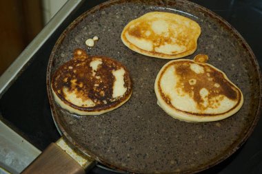 Yanında ahşap bir spatulayla tavada altın krep hazır olsun..