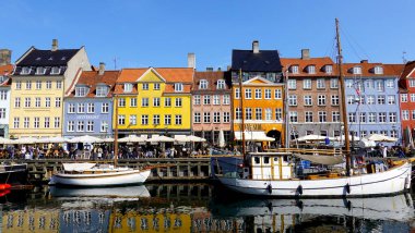 COPENHAGEN, DENMARK, APRIL 27, 2024: Kopenhag ikonik görüşü. Kopenhag, Danimarka 'nın merkezinde bahar mevsimi boyunca renkli evleri olan popüler Nyhavn liman bölgesi güneşli da