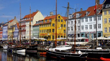 COPENHAGEN, DENMARK, APRIL 27, 2024: Kopenhag ikonik görüşü. Kopenhag, Danimarka 'nın merkezinde güneşli bahar mevsiminde renkli evleri olan popüler Nyhavn limanı.