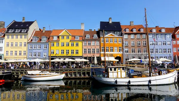 COPENHAGEN, DENMARK, APRIL 27, 2024: Kopenhag ikonik görüşü. Kopenhag, Danimarka 'nın merkezinde bahar mevsimi boyunca renkli evleri olan popüler Nyhavn liman bölgesi güneşli da