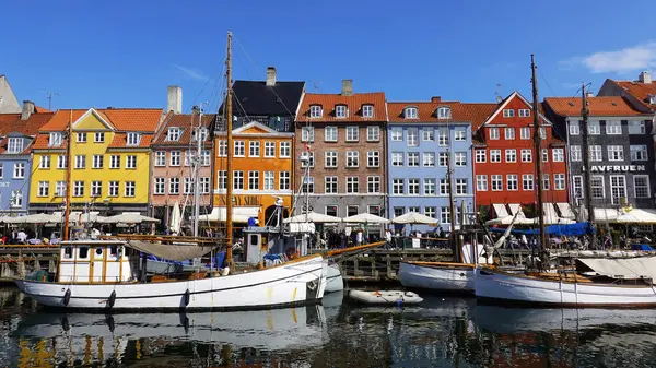 COPENHAGEN, DENMARK, APRIL 27, 2024: Kopenhag ikonik görüşü. Kopenhag, Danimarka 'nın merkezinde güneşli bahar mevsiminde renkli evleri olan popüler Nyhavn limanı.
