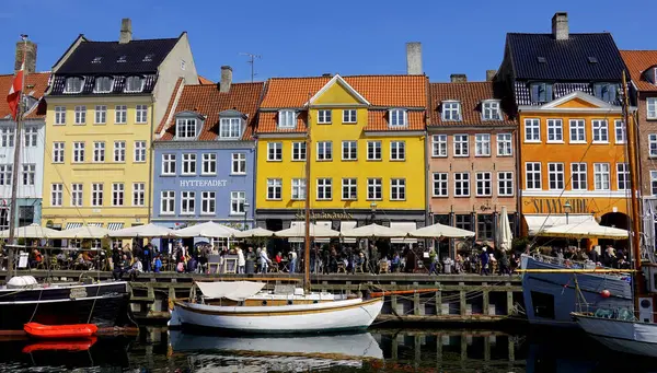 COPENHAGEN, DENMARK, APRIL 27, 2024: Kopenhag ikonik görüşü. Kopenhag, Danimarka 'nın merkezinde güneşli bahar mevsiminde renkli evleri olan popüler Nyhavn limanı.