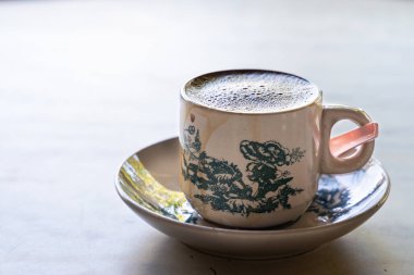 Geleneksel Çin fincanında ve Kopitiam 'da arka planda servis edilen Aromatik köpüklü kahve..