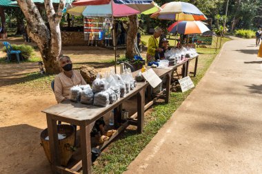 MAE HONG SON, THAILAND, 10 Mart 2023 Tham Nam Eğitim Merkezi girişinde balık yemi satan satıcılar. Ziyaretçiler mağaradaki geniş nehir sistemindeki balıkları beslemek için satın alabilirler..
