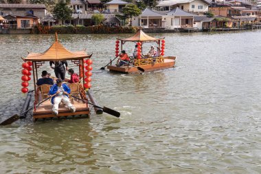 Tayland 'ın Mae Hong Son bölgesinde güzel bir köy olan Ban Rak Thai' nin manzaralı gölünde geleneksel olarak dekoratif bir teknede turist kayığı.