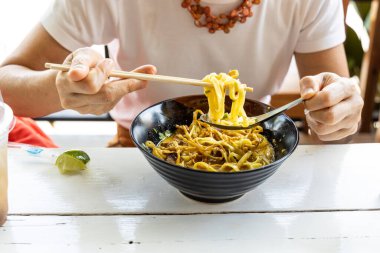 Khao soi yiyen kişi, Kuzey Tayland 'ın bir lezzeti körili erişte ve tavuktan oluşur.