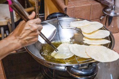 Evde kızartma yağıyla tavada karides krakeri kızartıyorum.