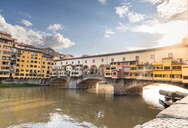 İtalya 'nın Toskana kentinin Floransa kentinde bulunan Arno Nehri üzerindeki tarihi ve ikonik eski köprü Ponte Vecchio' ya karşı akşam güneşi popüler bir turizm beldesi.