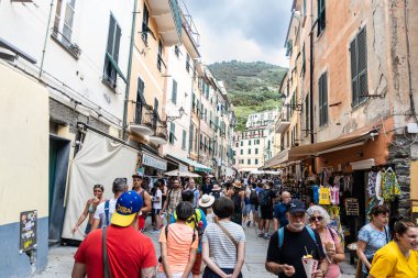 İtalya 'daki Cinque Terre yürüyüş yolu boyunca yer alan beş köyden biri olan Vernazza' da bir cadde boyunca yürüyen turist.