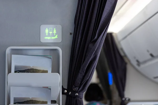 Oznakowanie Toaletowe Ścianie Kabiny Samolotu Oświetlonej Zielono Sugeruje Nie Jest — Zdjęcie stockowe