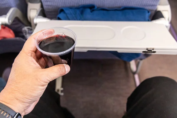 Pasażer Posiadający Kieliszek Czerwonego Wina Podawany Jako Część Wyboru Napojów — Zdjęcie stockowe