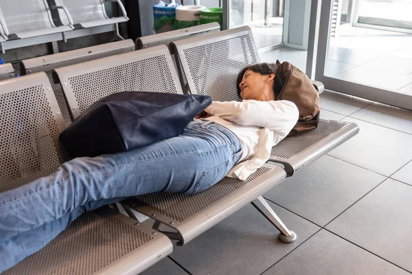 在候机楼候机区 疲惫的亚洲女人躺在椅子上等待航班 — 图库照片