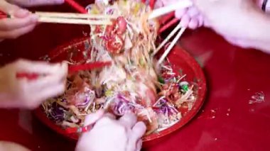 Çin Yeni Yıl yemeği kutlamalarında insanların birbirine karıştırıp fırlatması ve Yee Sang 'ın şarkı söylemesi, şans getirdiğine inanılıyor..