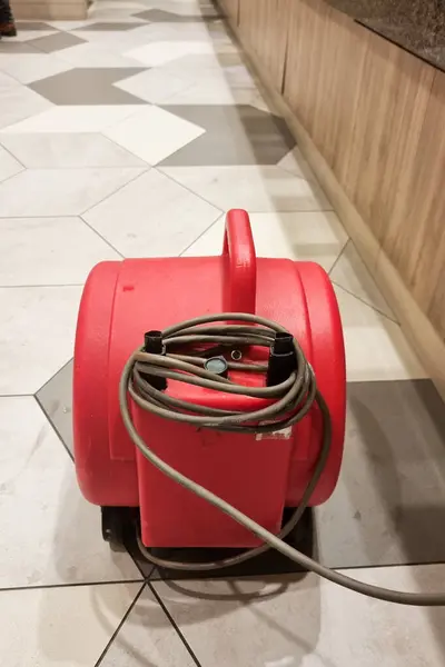 Close-up of portable floor dryer fan used in public washroom and toilet to dry the floor after washing and cleaning, keeping public space hygienic