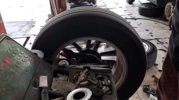 车间车库用轮式平衡机平衡汽车轮胎工人的关门 — 图库视频影像