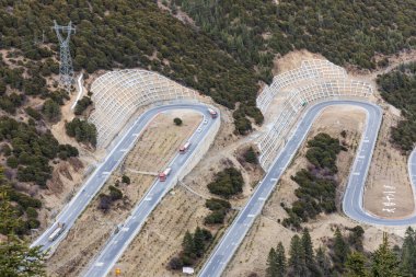 Çin G318 ulusal otobanına yakın plan 18 viraj. Yajiang ilçe merkezinden Sichuan 'daki Jianziwan Dağı Geçidi' ne kadar uzanan yolun yamaçtan 26km yukarıya estiği popüler turistik merkezlerden biri.