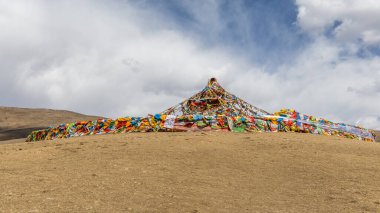 Çoklu Tibet dini dua bayrakları Litang Manastırı 'nın yanındaki tepede bir ahmağı süsledi ve giydirdi. Litang, Sichuan, Çin 'de popüler turizm merkezi..