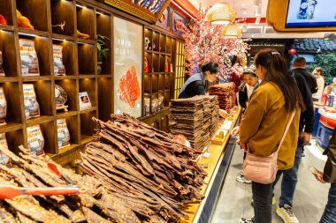 Shoppers shopping for food delicacies in Kuanzhai alley, Chengdu. Dried beef and yak jerky are popular snacks. clipart