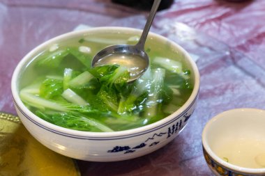 Sade ve otantik Sichuan mutfağı. Yeşil yapraklı sebze çorbası servis ediliyor.