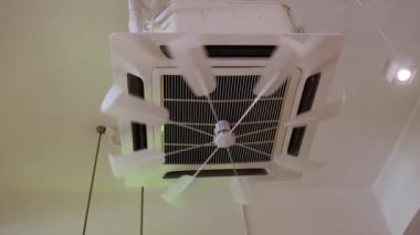 Odaya soğuk havayı eşit olarak dağıtmak için klima kaset ünitesine bağlı dönen pervane kapağı. Hareket bulanıklığı..