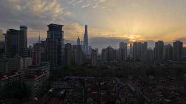 Çin şehir merkezinde Şangay 'da manzaralı altın güneş doğuyor. Binalar ve yüksek açılı evler var.