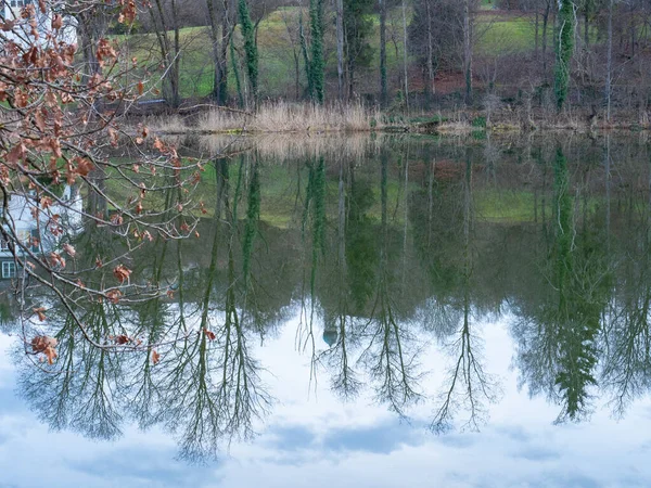 Beautiful small lake in Bavaria, Germany: Trees and a church are reflected in a small lake.