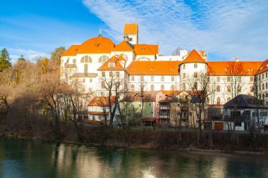 Almanya 'nın Fuessen kalesine doğru Lech Nehri' nin üzerinde ünlü bir manzara. Tarihi binalar sabah gün ışığında ortaya çıkar..