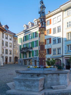 Historic buildings and a fountain in the afternoon sunlight. Beautiful situation in the city of Biel, Switzerland.