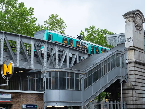 Historic elevated metro station La Chapelle in Paris, France, famous for its construction and architecture. Situation with a train departing. 
