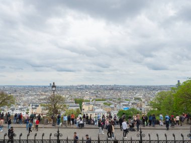 Basilika Sacre-Coeur de Montmartre 'nin önündeki manzara, Fransa' nın Paris kenti üzerinde muhteşem bir manzara sunuyor. Kasabaya bakan bir sürü insan var..