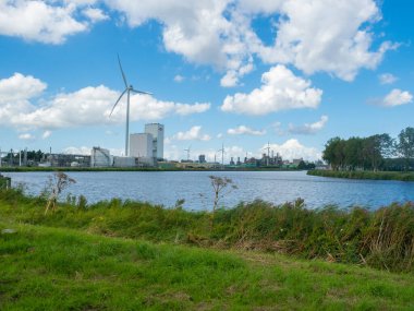 Hollanda 'nın Ems ağız bölgesinde büyük sanayi bölgeleri vardır. Nehrin üzerinden santrallere ve rüzgar jeneratörlerine doğru bakın..