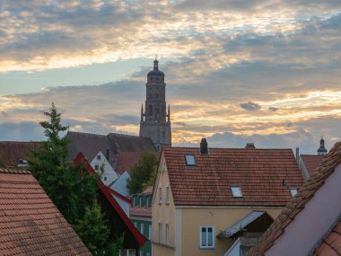 Almanya 'nın Noerdlingen kentinin eski duvarının etrafında dolaşarak ünlü simetrik olarak yuvarlak şehir merkezi yapısına güzel manzaralar sunuyor. Şehir kilisesine doğru tarihi binalara bakın..
